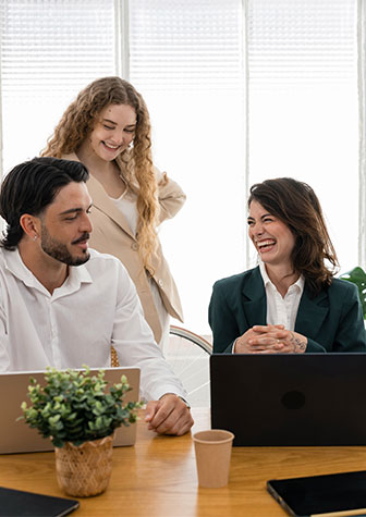 Drei Mitarbeitende im gemeinsamen Austausch symbolisieren Teamarbeit, berufliche Entwicklung und neue Karrierechancen im Unternehmen.