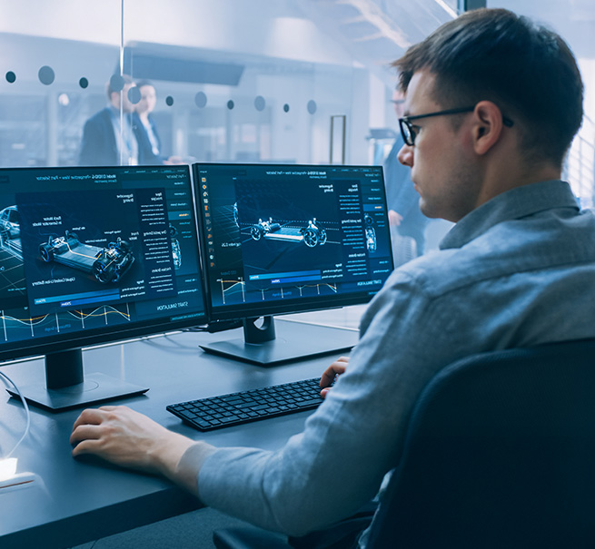 Partner mit Branchenwissen und Netzwerk Ingenieur arbeitet konzentriert an zwei Monitoren mit CAD-Software in einem modernen Büro.