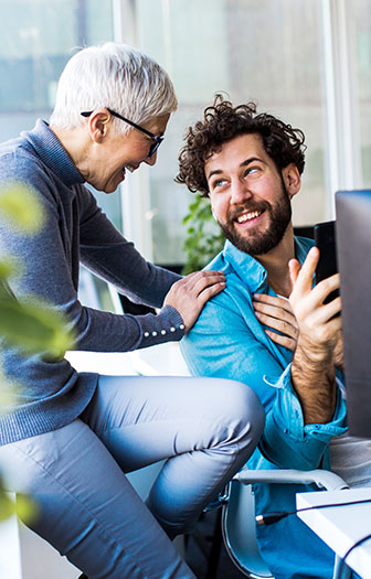 Eine Führungskraft legt einem Mitarbeiter die Hand auf die Schulter – Symbol für Unterstützung im Job.
