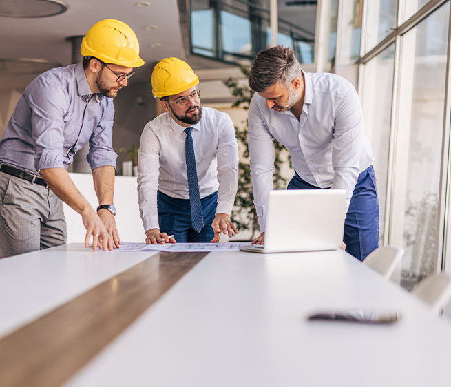 Besprechung von Bauplänen an einem Schreibtisch