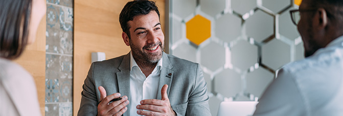 Personalberater spricht im Meeting mit zwei Kandidaten – Austausch über Karrierechancen im Legal-Sektor.