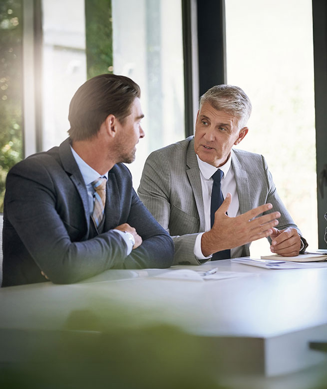 Gespr&auml;chssituation zwischen 2 Herren im B&uuml;ro am Schreibtisch