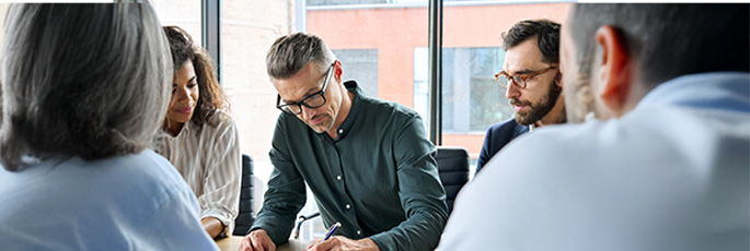 Das passende Modell für Ihr Unternehmen Team von Geschäftsleuten arbeitet gemeinsam an einem Tisch – Zusammenarbeit und Vertragsfindung.